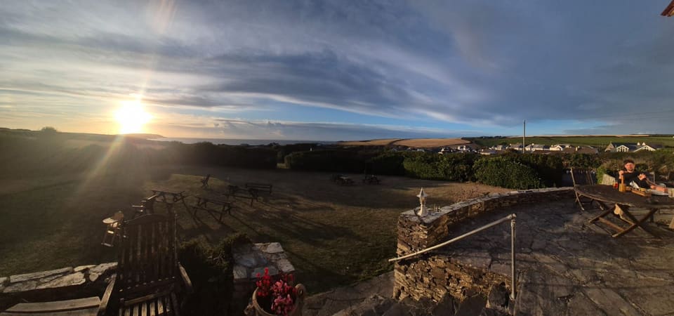The stone-walled terrace and lawn at sunset